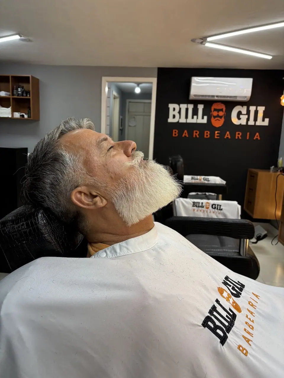 Cliente de barba branca e cheia no fim do atendimento