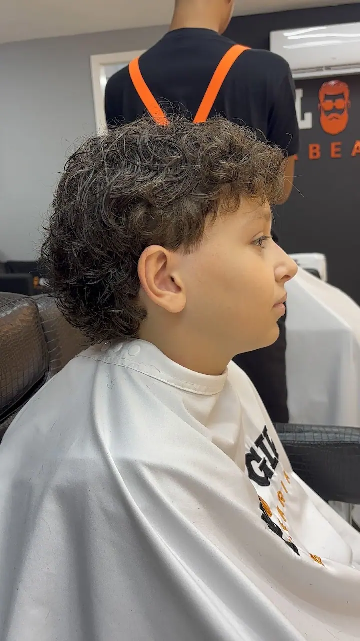 Menino de cabelo cacheado na cadeira