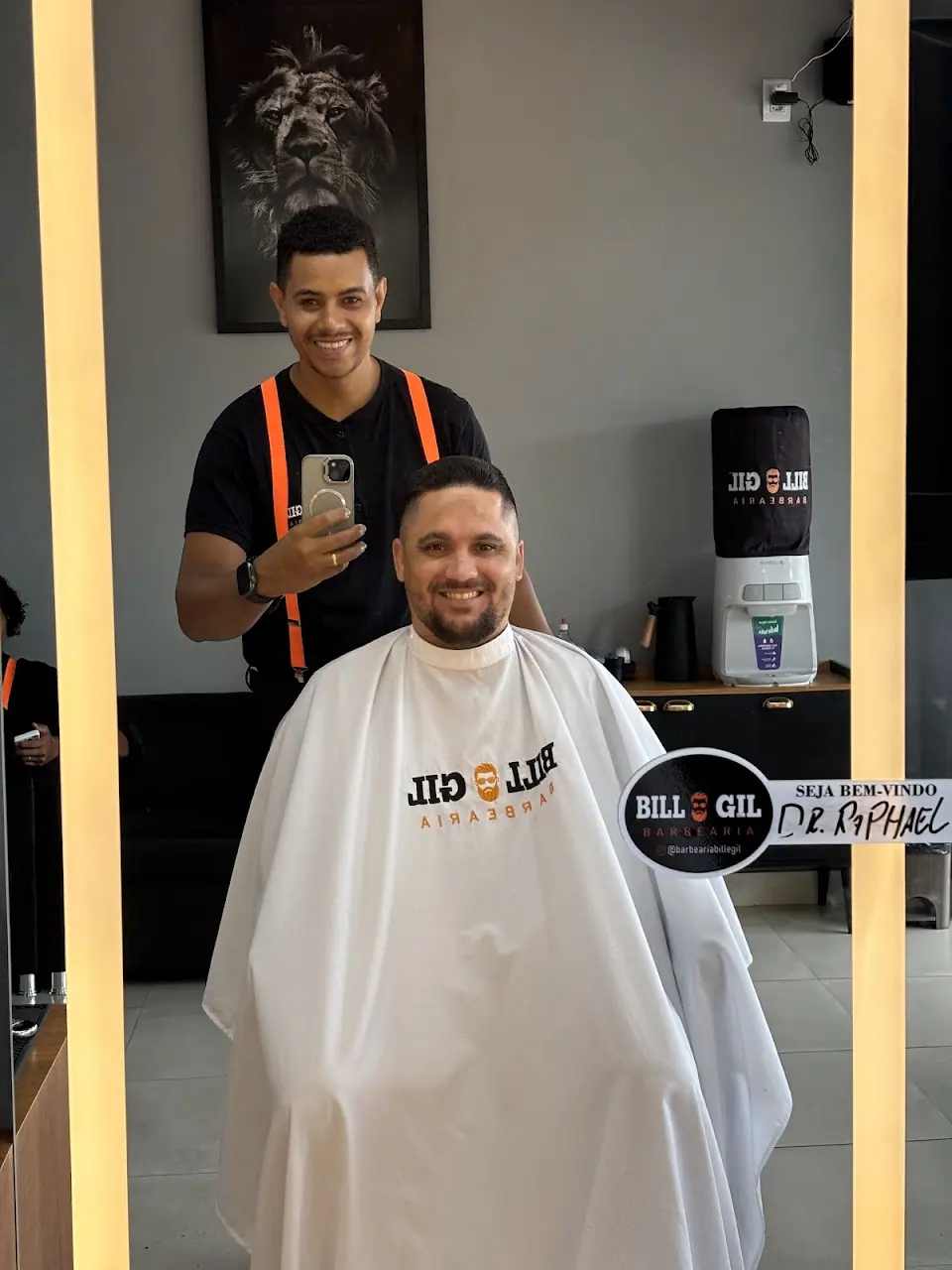 Barbeiro e cliente sorrindo no espelho de LED