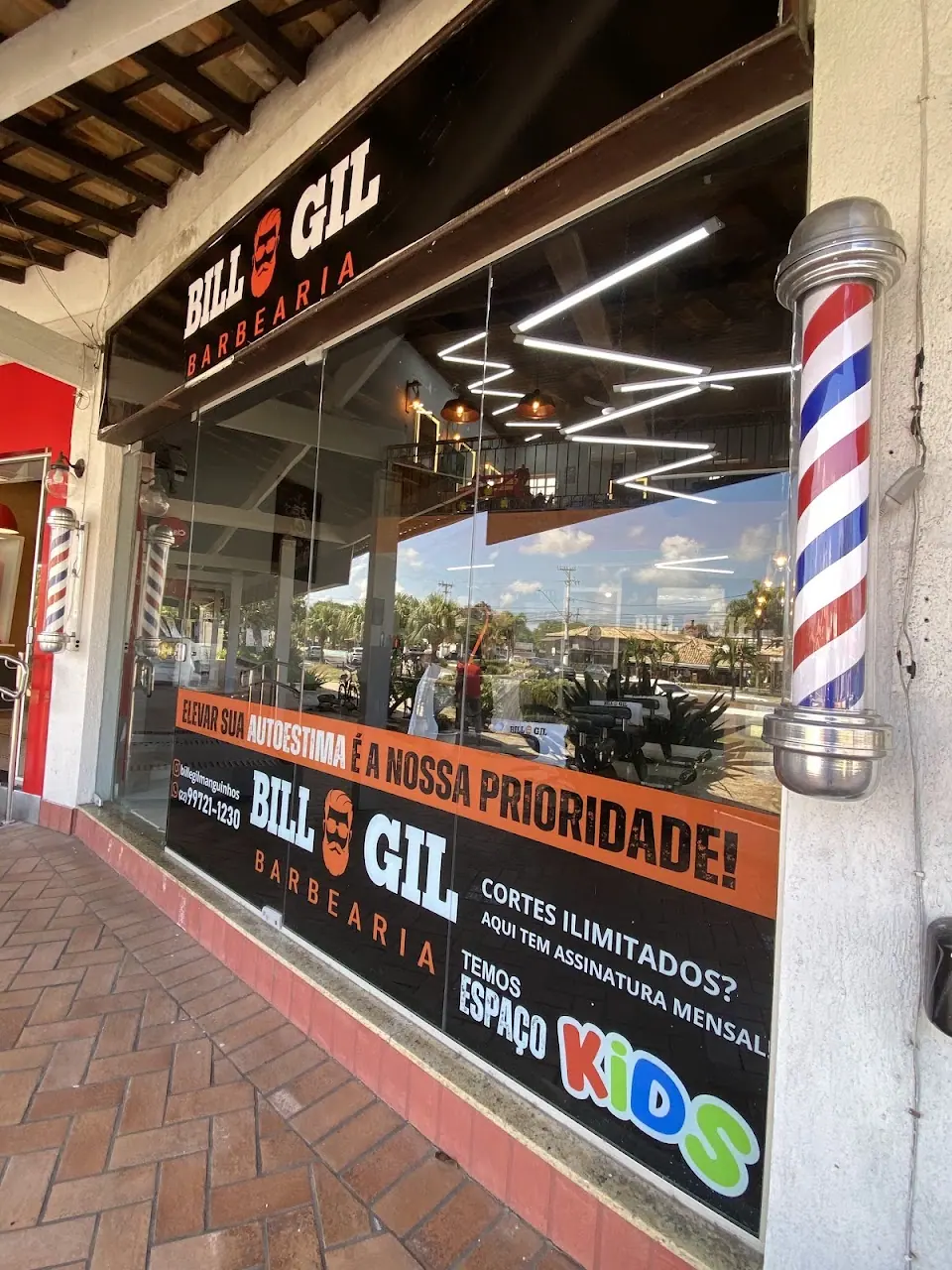 Vitrine da Bill & Gil com poste de barbeiro e os avisos de espaço kids e assinatura mensal