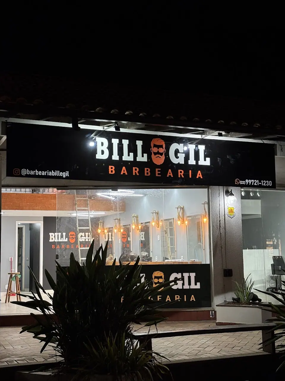 Fachada da Bill & Gil à noite, com letreiro aceso